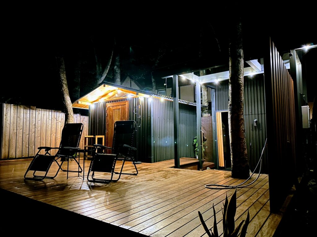 夜のライティングが幻想的にウッドデッキを照らす88PEAKSの外気浴スペース