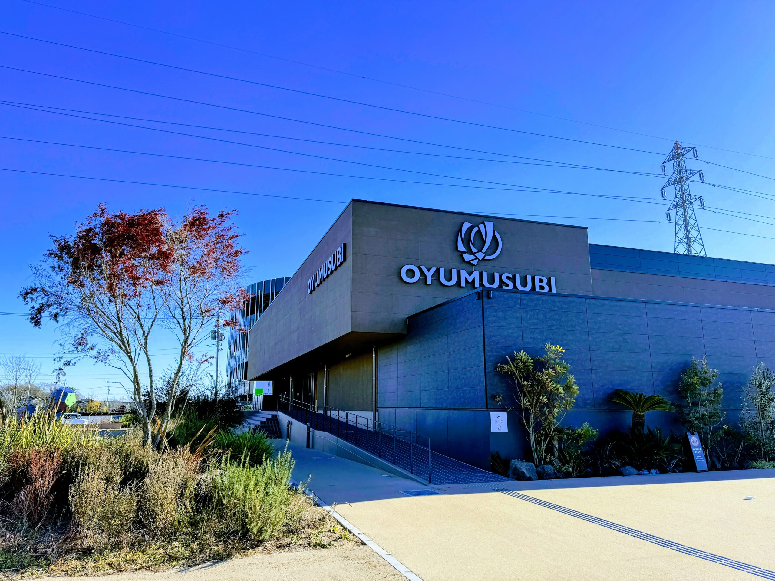 常総ONSEN&SAUNA お湯むすび 施設外観とOYUMUSUBIのロゴ