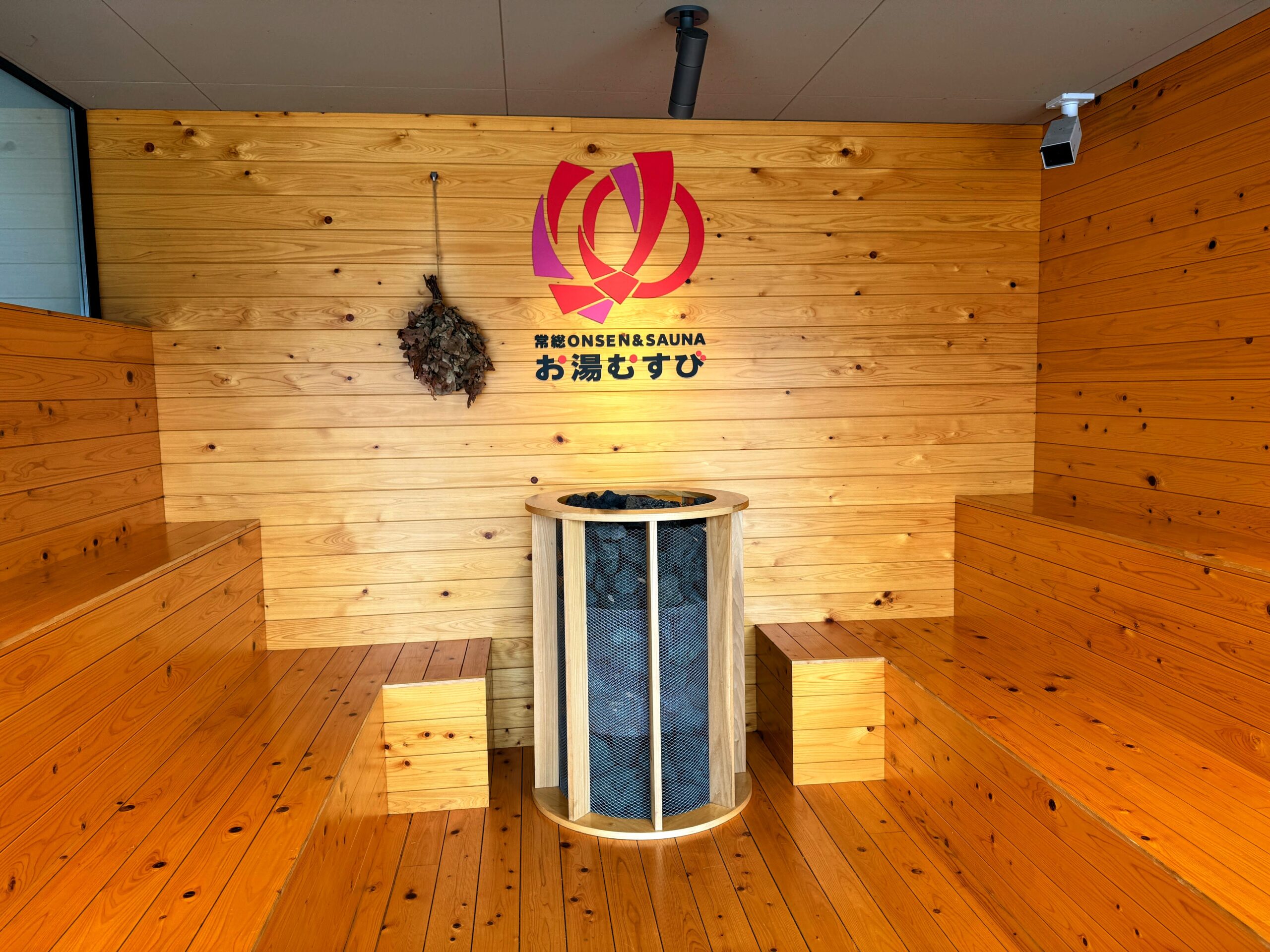 常総ONSEN&SAUNA お湯むすび 建物入口横に飾られたロゴとヴィヒタ