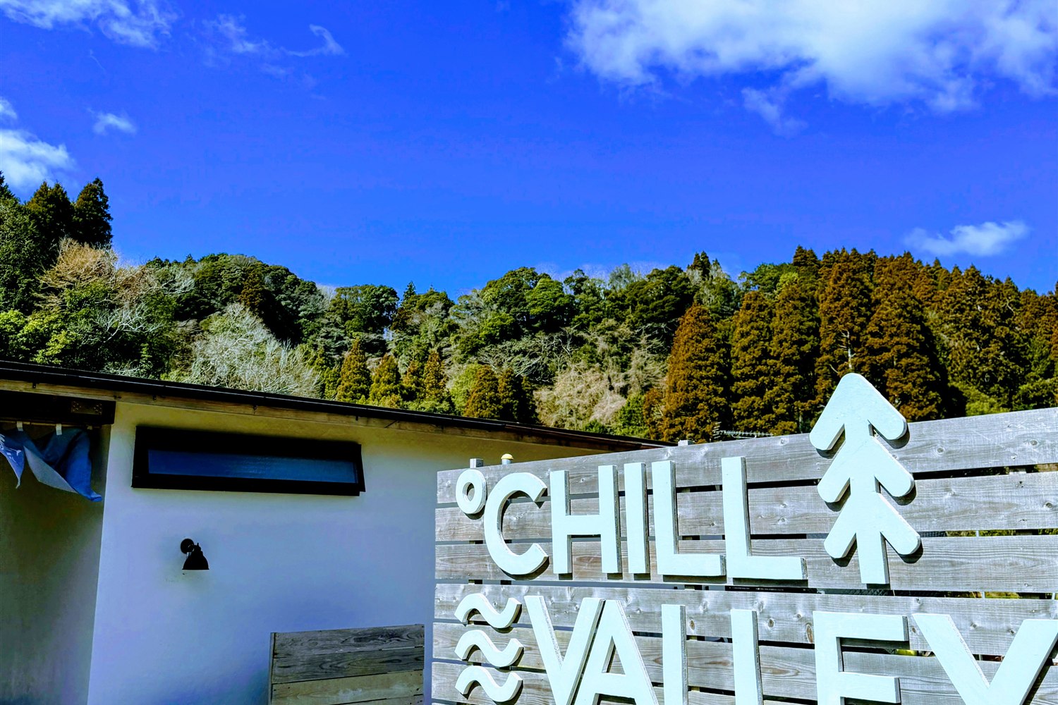 ℃HILL VALLEY 養老渓谷の入口に立つ木製ロゴ看板と青空、房総の山並み