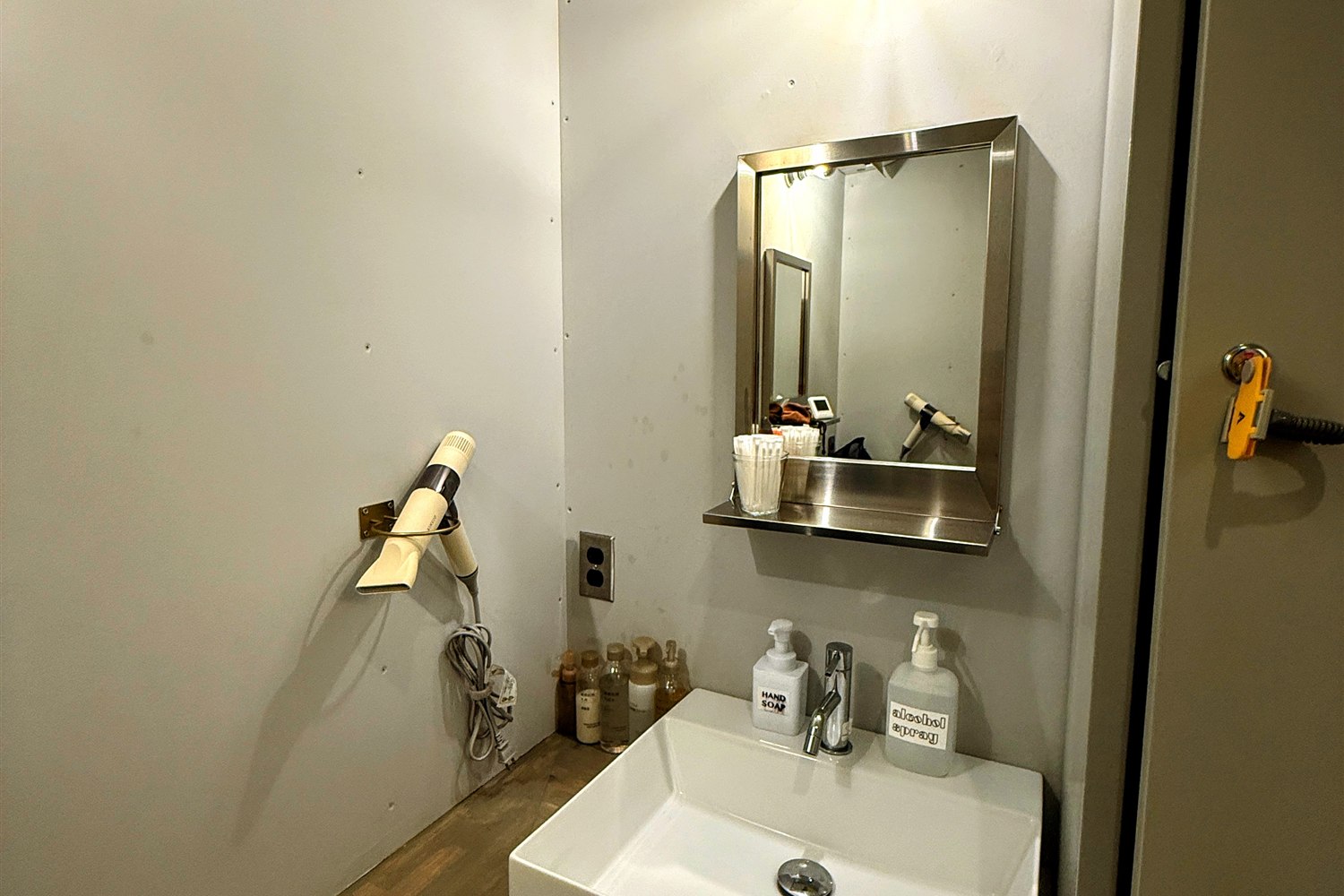 WALLOWS sauna & dinerのパウダースペース。洗面台とドライヤー、鏡、ロッカーが備えられている