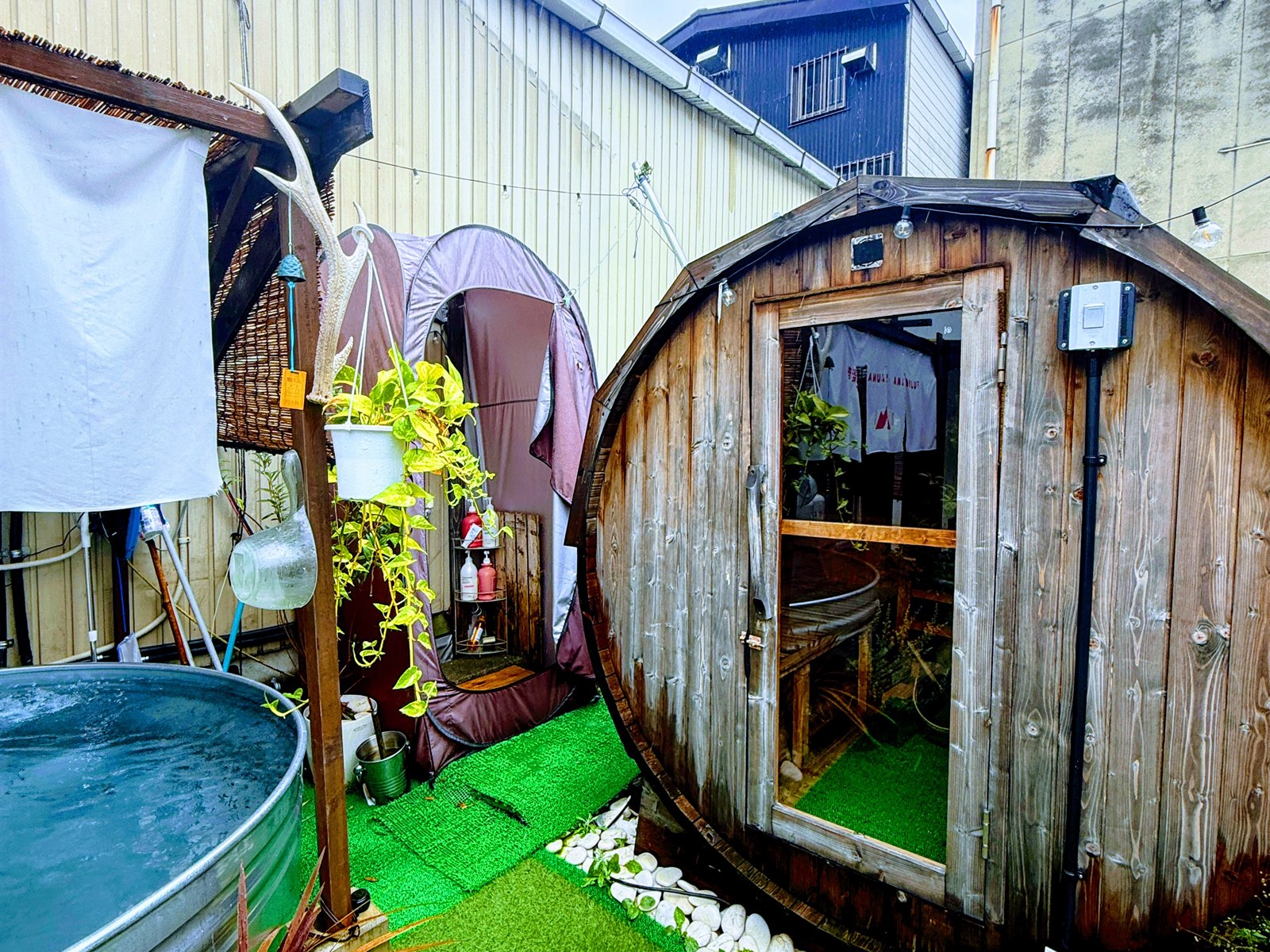 FUJIYAMA SAUNA倶楽部のバレルサウナ外観。樽型の木製サウナと金ダライ水風呂