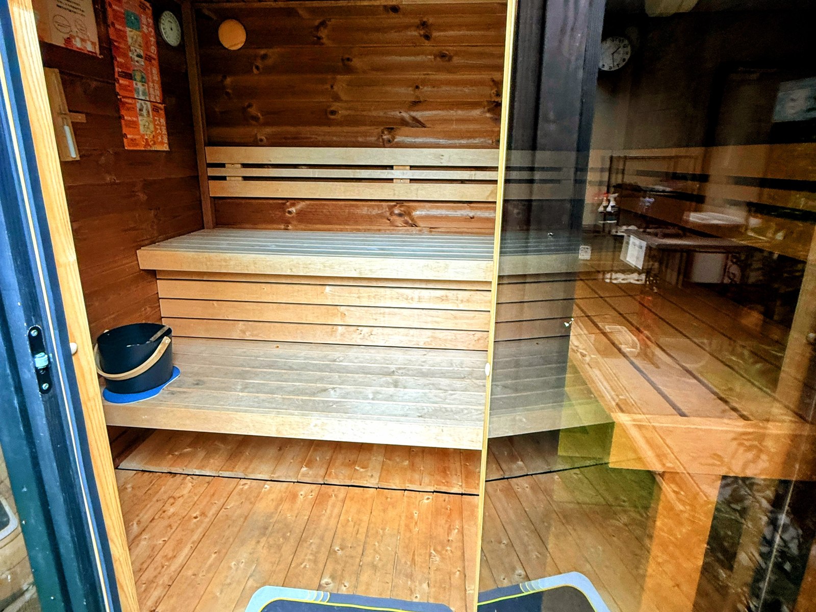 FUJIYAMA SAUNA倶楽部の小屋サウナ内部。木のベンチとガラス張りの明るい室内