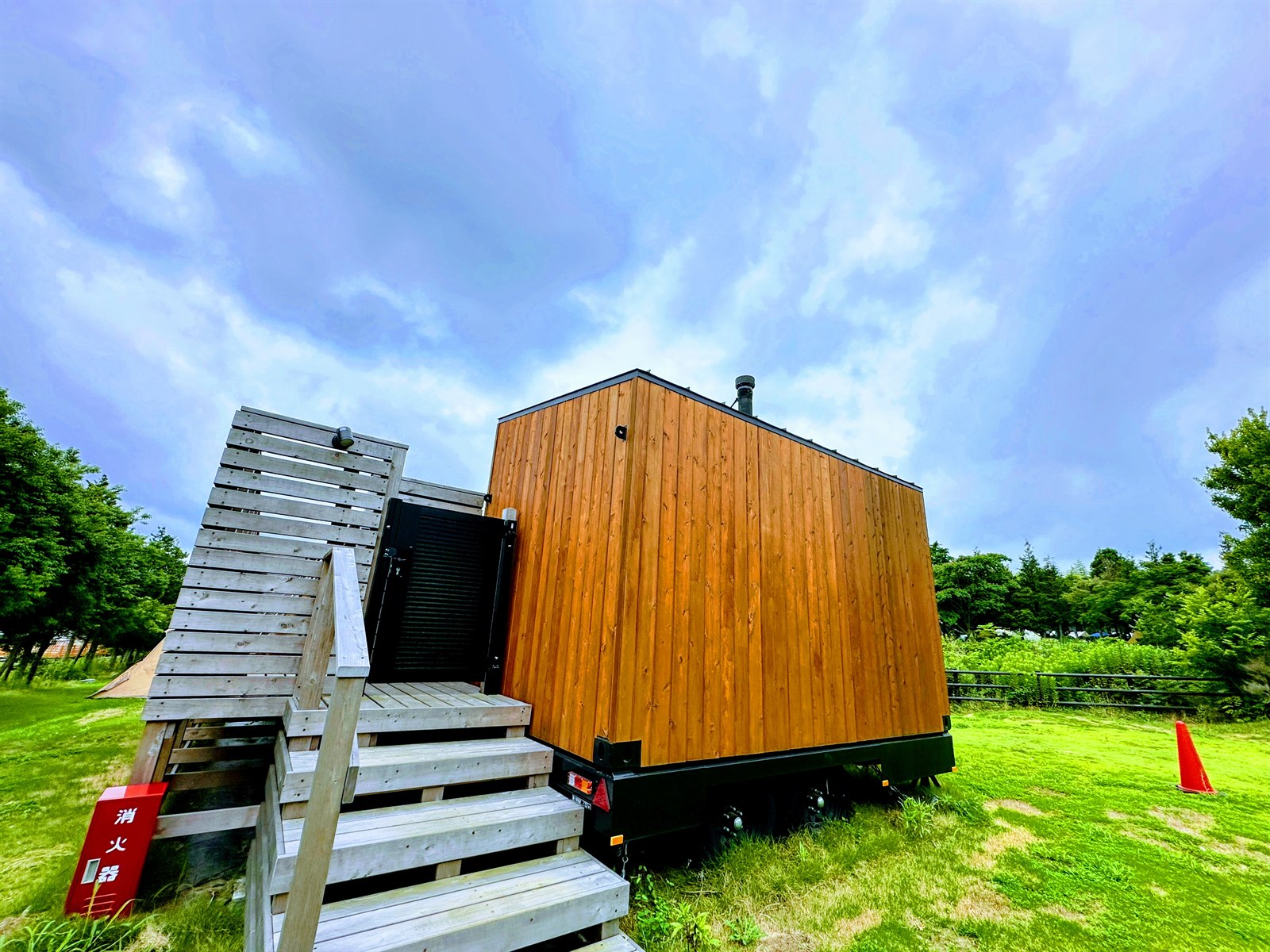 ogawa GRAND lodge FIELDのサウナ小屋の外観。芝生の上に立つトレーラー型の木製サウナ