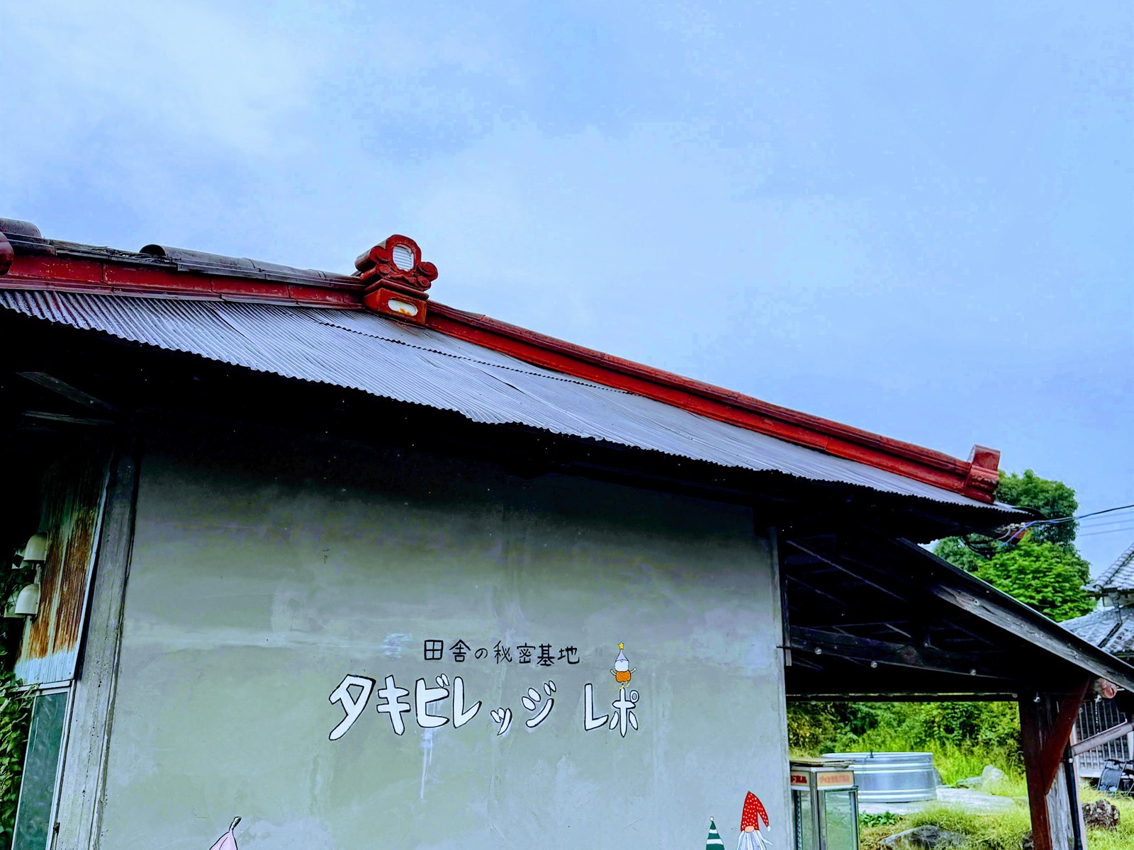 LEPO by takivillageの外観。古民家の壁に「田舎の秘密基地 タキビレッジ レポ」の文字とガーデンチェアが並ぶ