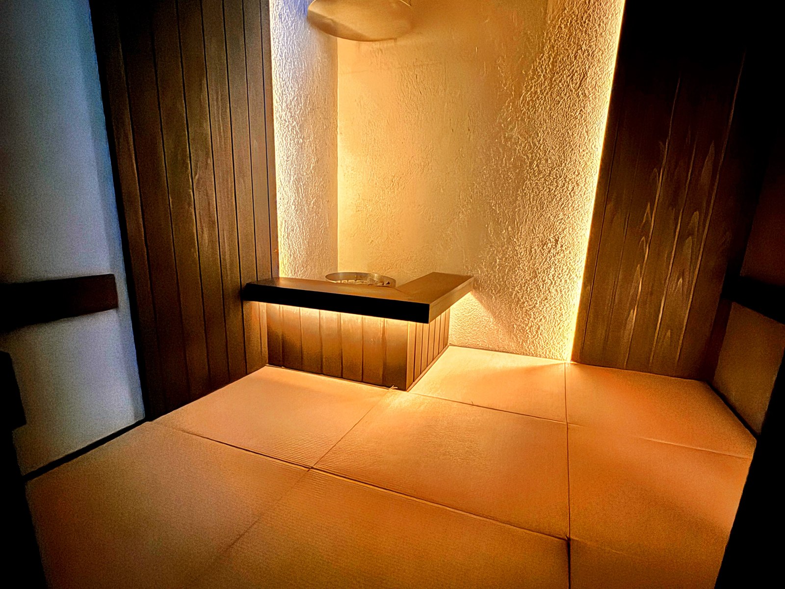SAUNA OOO SAPPOROの座敷タイプのサウナ室。畳敷きで天井が低く、間接照明とサウナストーブ