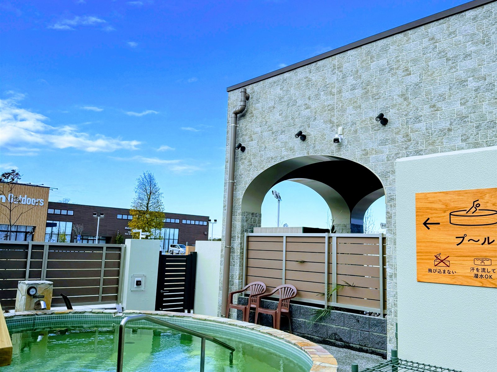 YUBUNE SAUNA PARKの温水プール「くつろぎ湯」。丸い石造りのプールと「プール（飛び込まない・汗を流して潜水OK）」の案内サイン