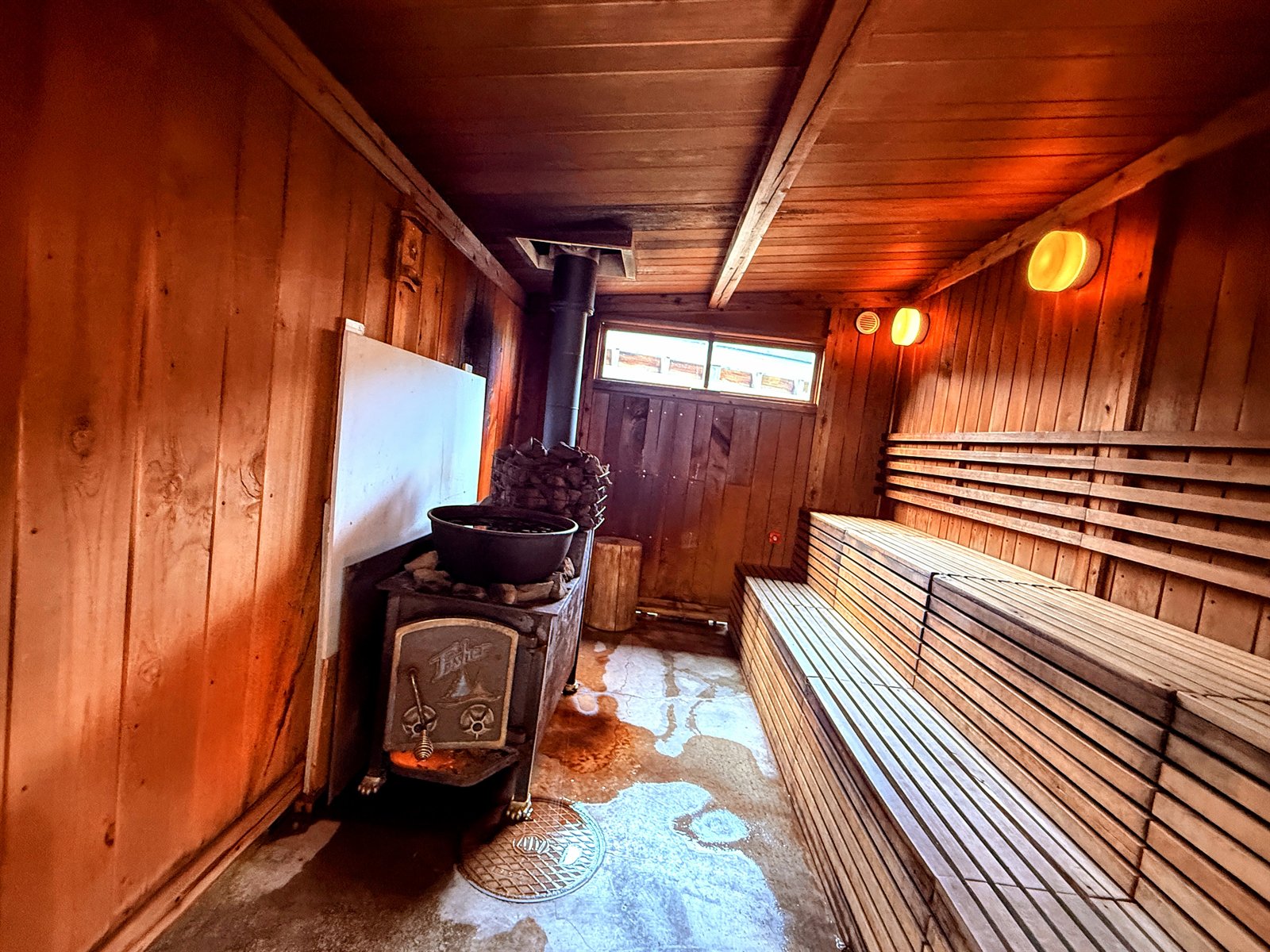 小屋サウナの薪ストーブと木のベンチ