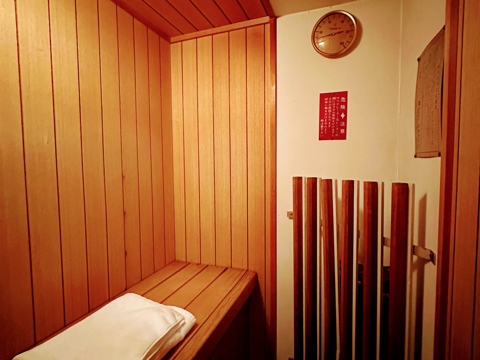 HOTEL SEEDS 桶川店の客室サウナ内部。木のベンチと温度計、サウナマット